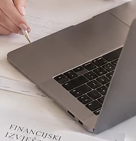 Prijenosno računalo i financijski dokumenti na stolu